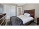 Bedroom features a queen bed with dark wood frame, closet, and dresser at 18668 E Vassar Dr, Aurora, CO 80013