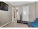 Bedroom area with a treadmill and doorway leading to the bathroom, offering exercise and convenience at 18668 E Vassar Dr, Aurora, CO 80013