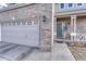 Charming home featuring a gray brick exterior, two-car garage, and welcoming front porch at 18668 E Vassar Dr, Aurora, CO 80013