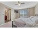 Main bedroom features ceiling fan, large window with blinds, and adjacent primary bath at 18668 E Vassar Dr, Aurora, CO 80013