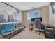 Office space featuring a large window, desk setup, and cozy futon at 18668 E Vassar Dr, Aurora, CO 80013