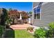 Landscaped backyard with a round patio, outdoor seating, mature trees, and manicured lawn at 12427 James Ct, Broomfield, CO 80020