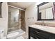Modern bathroom featuring a glass shower, granite vanity, and large mirror with black frame at 12427 James Ct, Broomfield, CO 80020