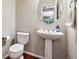 Stylish powder room with a pedestal sink, round mirror, and classic fixtures at 12427 James Ct, Broomfield, CO 80020