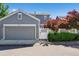 Detached garage featuring a gray door, red trees, and a fenced-in yard at 12427 James Ct, Broomfield, CO 80020