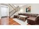 The living room showcases stylish stairs and a comfortable leather sectional couch at 12427 James Ct, Broomfield, CO 80020