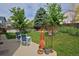 Lush backyard with well-maintained lawn, a patio set, mature trees, and wooden fence at 13441 Cherry St, Thornton, CO 80241