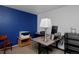 Bedroom with a wooden desk, blue accent wall, neutral carpet, and a bright window at 13441 Cherry St, Thornton, CO 80241