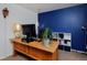 Bedroom with a wooden desk, blue accent wall, neutral carpet, and cuckoo clock at 13441 Cherry St, Thornton, CO 80241
