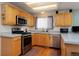 The kitchen has stainless steel appliances and oak cabinets at 13441 Cherry St, Thornton, CO 80241