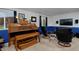 Finished room with organ, tiered seating, blue accents, and dark, modern recliners at 13441 Cherry St, Thornton, CO 80241