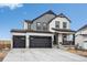 Striking two-story home with a three-car garage, and manicured gravel landscaping at 693 Penn Rd, Elizabeth, CO 80107