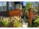 Backyard with a wooden fence, stone path, and decorative grasses at 48 Newport St, Denver, CO 80230