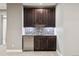 Basement wet bar with dark wood cabinets at 48 Newport St, Denver, CO 80230