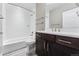 Modern bathroom with white subway tiles, dark vanity, and a shower/tub combo at 48 Newport St, Denver, CO 80230