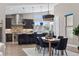 Modern kitchen with dark cabinetry, stainless steel appliances, and an island with seating at 48 Newport St, Denver, CO 80230