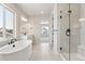 Bright bathroom showcasing a standalone tub, glass-enclosed shower, and double sinks with modern fixtures at 1714 Morgan Dr, Erie, CO 80516