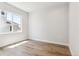 A bedroom with hardwood floors and a window overlooking the front yard at 1714 Morgan Dr, Erie, CO 80516
