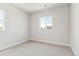 Cozy bedroom with neutral carpet and walls, enhanced by natural light streaming through the window at 1714 Morgan Dr, Erie, CO 80516