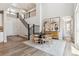 Bright dining room featuring hardwood floors, a staircase with black iron railing, and views into the foyer at 1714 Morgan Dr, Erie, CO 80516