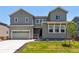 Charming two-story home featuring a gray exterior, well-maintained lawn, and attached two car garage at 1714 Morgan Dr, Erie, CO 80516