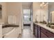 Bright and modern bath with a soaking tub, tile floors, and double granite vanity at 504 E Dry Creek Pl, Littleton, CO 80122