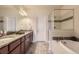 Primary bath featuring double vanity with granite counters, soaking tub and glass enclosed shower at 504 E Dry Creek Pl, Littleton, CO 80122