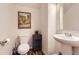 Cozy half bathroom features decorative artwork and pedestal sink with modern finishes at 504 E Dry Creek Pl, Littleton, CO 80122