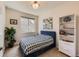 Bright bedroom with large window, blue upholstered bed, carpeted floor and modern decor at 504 E Dry Creek Pl, Littleton, CO 80122