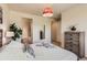 Comfortable bedroom with a decorative red chandelier, dresser, and queen bed with white bedding at 504 E Dry Creek Pl, Littleton, CO 80122