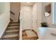Bright foyer with carpeted stairs, wood-look floors, a coat closet, and a white chair at 504 E Dry Creek Pl, Littleton, CO 80122