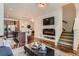 Open-concept living area with modern fireplace, hardwood floors, and seamless connection to kitchen and dining at 504 E Dry Creek Pl, Littleton, CO 80122