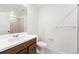 Bright bathroom featuring a modern vanity with a white countertop, tile flooring, and a shower with tiled walls at 17117 W 91St Ln, Arvada, CO 80007