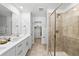 Bathroom featuring double vanity, walk-in closet and glass shower at 17117 W 91St Ln, Arvada, CO 80007