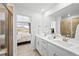 Bathroom with double sink vanity, quartz countertop and modern fixtures next to bedroom at 17117 W 91St Ln, Arvada, CO 80007