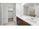 Bathroom with dual sinks, large mirror, dark wood cabinets and glass shower at 17117 W 91St Ln, Arvada, CO 80007