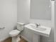 Elegant half bath with white pedestal sink, modern fixtures, and neutral decor at 17117 W 91St Ln, Arvada, CO 80007
