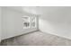 Bright bedroom features neutral carpet, white walls, and a view of neighboring homes at 17117 W 91St Ln, Arvada, CO 80007