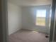 Bright bedroom with neutral carpet and expansive views from a large window at 17117 W 91St Ln, Arvada, CO 80007