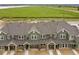 New construction townhomes featuring attached garages, neutral paint, and meticulous landscaping near a green field at 17117 W 91St Ln, Arvada, CO 80007