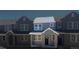 Charming townhome featuring a covered entryway with brick columns, large windows, and blue siding at 17117 W 91St Ln, Arvada, CO 80007