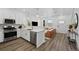 Modern kitchen with stainless steel appliances, white cabinets, and an open layout to the living area at 17117 W 91St Ln, Arvada, CO 80007
