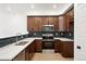 Modern kitchen features stainless appliances, wooden cabinets, and white countertops at 17117 W 91St Ln, Arvada, CO 80007