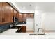 Modern kitchen featuring wooden cabinets, stainless steel appliances, and black hexagon backsplash at 17117 W 91St Ln, Arvada, CO 80007