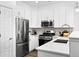 Bright kitchen features stainless steel appliances, white cabinets, and modern countertops at 17117 W 91St Ln, Arvada, CO 80007