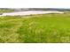 Scenic view of a spacious green field next to a retention pond in a quiet residential area at 17117 W 91St Ln, Arvada, CO 80007