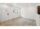 Open living room with neutral carpet and a view of the front door and kitchen at 17117 W 91St Ln, Arvada, CO 80007