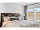 Bedroom featuring large window, decorative headboard and cozy decor at 17117 W 91St Ln, Arvada, CO 80007