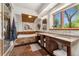 Spacious bathroom with wood accents, stone floors, double vanity, and tub under a window at 740 Carr St, Lakewood, CO 80214