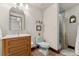 Bathroom with wooden vanity, toilet, shower behind a curtain and tile floors at 740 Carr St, Lakewood, CO 80214